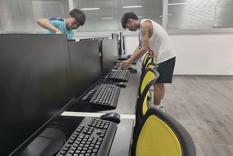 图7：计算机应用技术专业的同学擦洗桌子和摆放好键盘鼠标.jpg