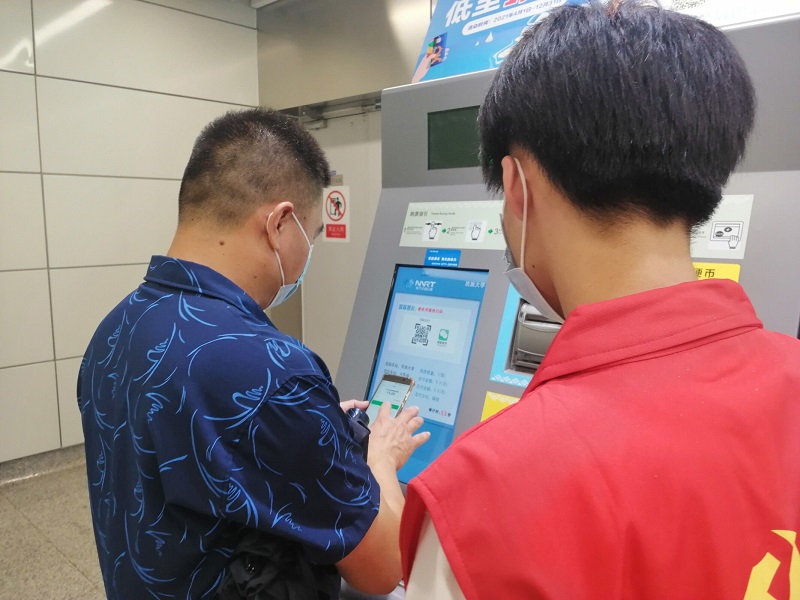 1626247339786602.jpg 图3:学生第二党支部党员引导地铁站的行人购票.jpg