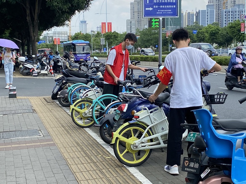 1626247267925033.jpg 图2:学生第二党支部党员在大学东路整理摆放路边乱停放的共享单.jpg
